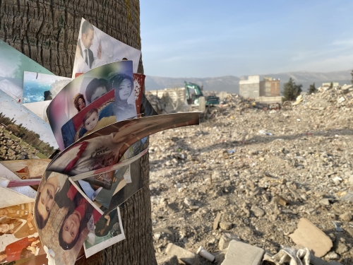 Enkazda bulunan fotoğraflar bir direğe asılmış